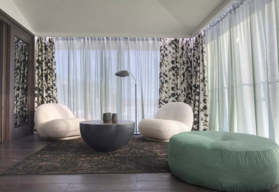 Elegant Room with Three Comfortable Chairs and a Table in Villa Geba Suite Selene